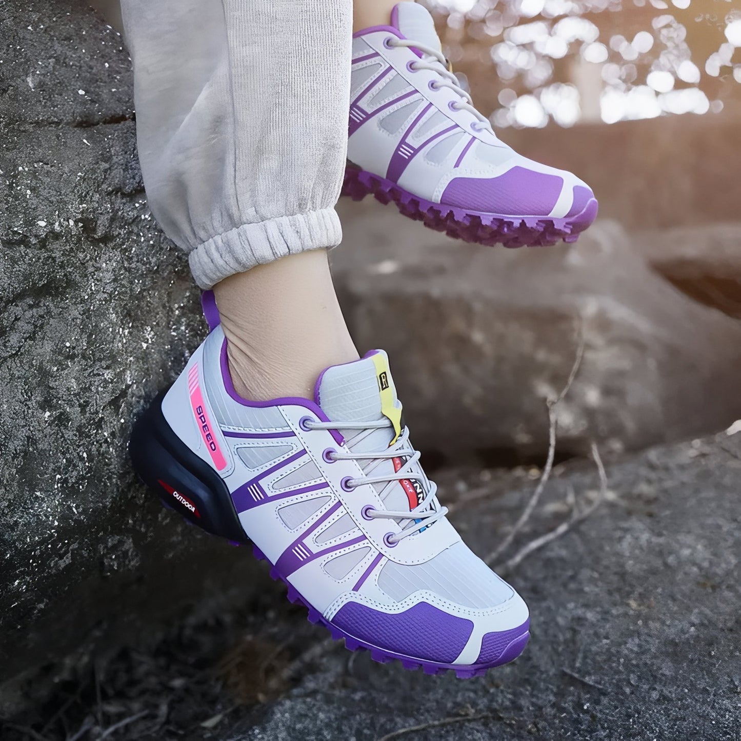 Chaussure Randonnée Femme Légère Violette portée sur rocher - Gris et Violet - Turquoise et Fuchsia