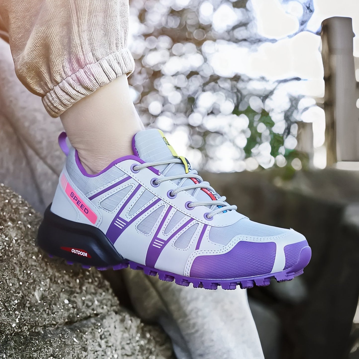 Chaussure Randonnée Femme Légère Violette portée sur un rocher - Gris et Violet - Turquoise et Fuchsia