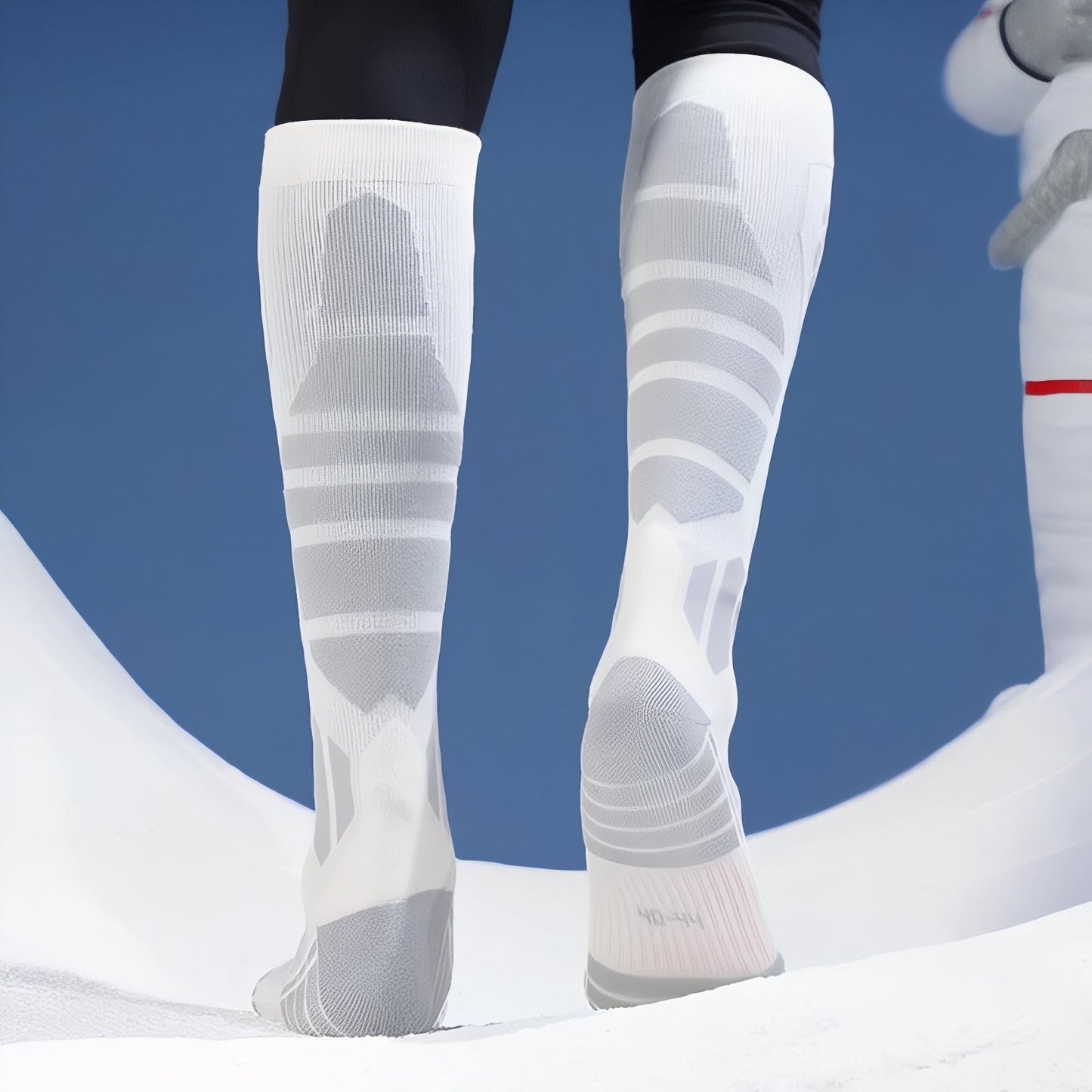 Chaussette Haute Randonnée portée sur un fond neigeux - Blanc - Noir et Gris - Noir et Lavande